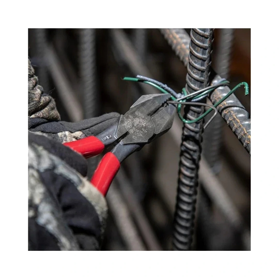 Pinzas de electricista enganchando alambre en una estructura metálica